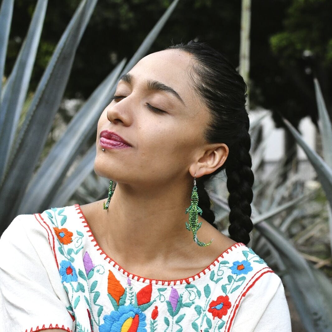 woman wearing green littlefoot lizard animal beaded earrings