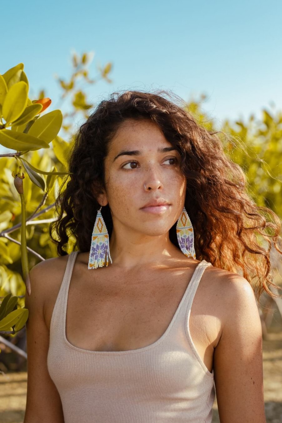 woman wearing white gold light purple fringe beaded earrings